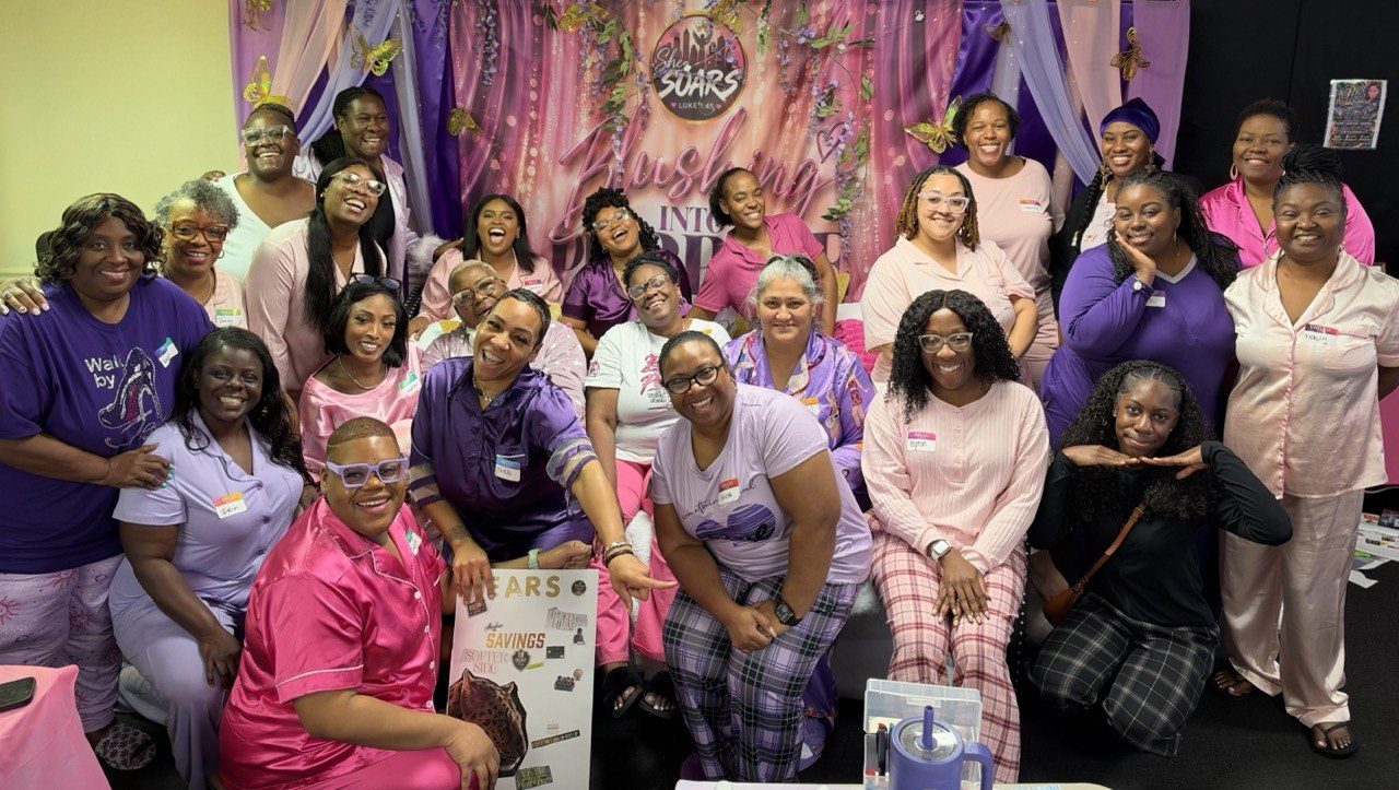 The sold-out room of sisters in pajamas gathered at the Blushing Into Purpose backdrop