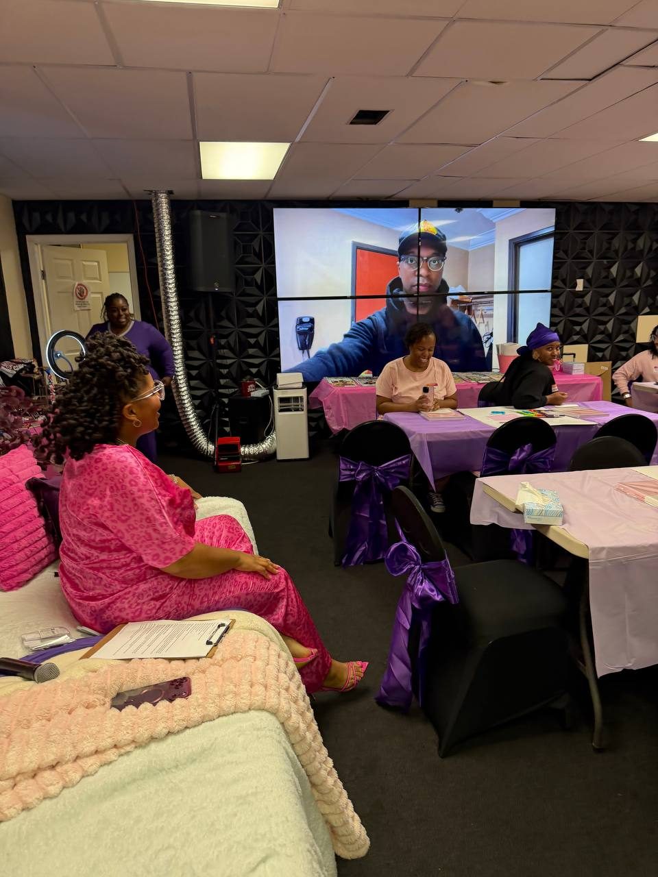 The room gathered as Apostle Calvin Miller joins on the big screen