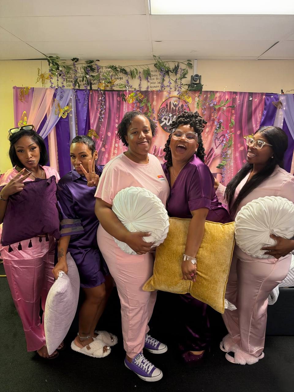 Five sisters posing with pillows in front of the backdrop